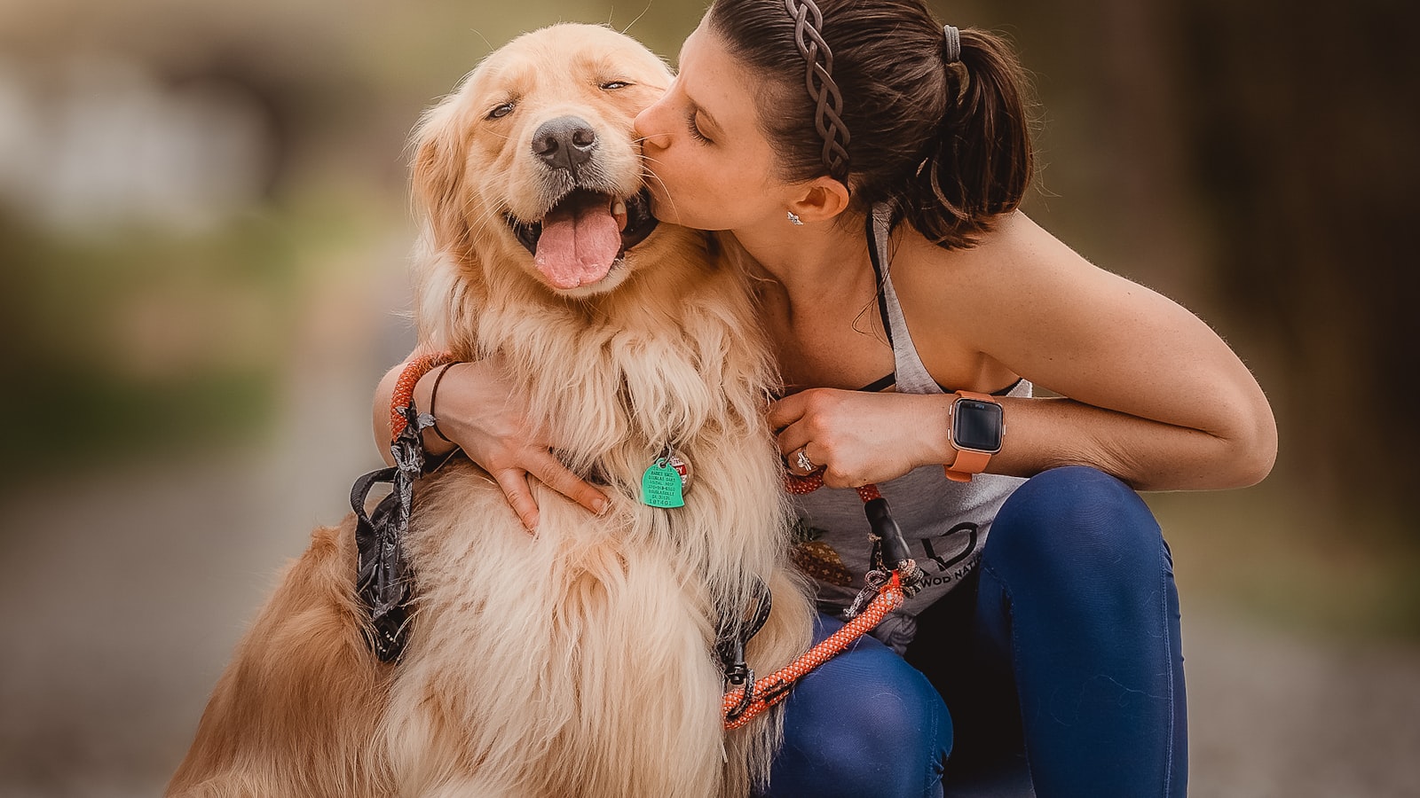 愛犬に寄り添いキスをする飼い主の女性