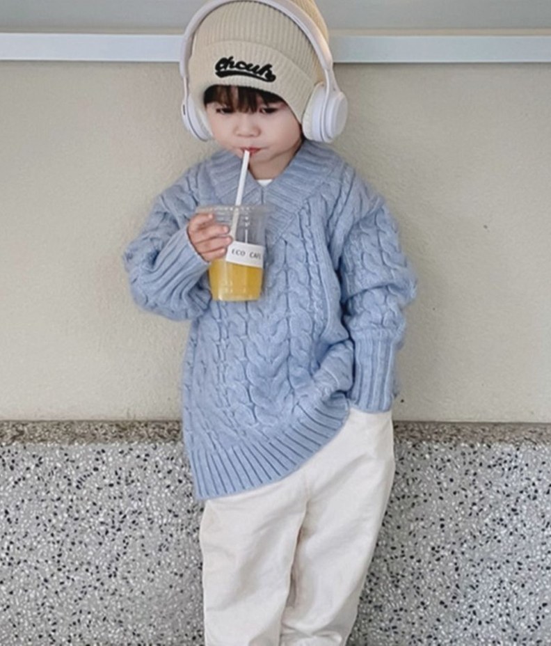 アイスブルーのケーブル編みニットを着た子ども